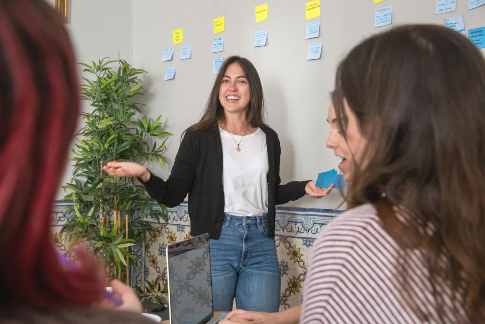 Team meeting around a whiteboard with business strategy diagrams and growth charts